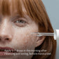 Close-up of a woman's face with a dropper applying a skincare product.