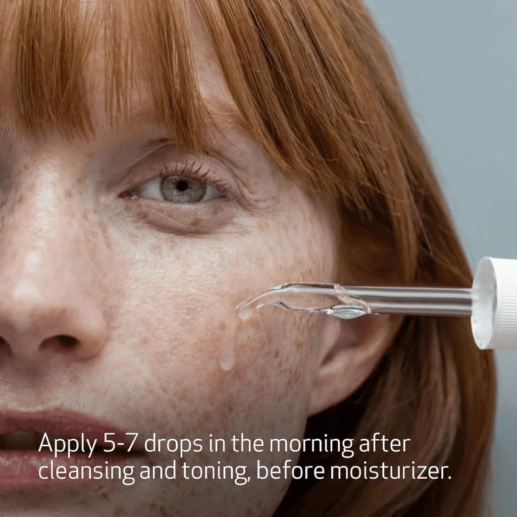 Close-up of a woman's face with a dropper applying a skincare product.
