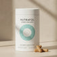 A white cylindrical tub of Nutrafol Women's Balance dietary supplement with a teal concentric circle logo, set on a beige surface with three tan capsules in front. The background is a textured beige wall with soft diagonal shadows.