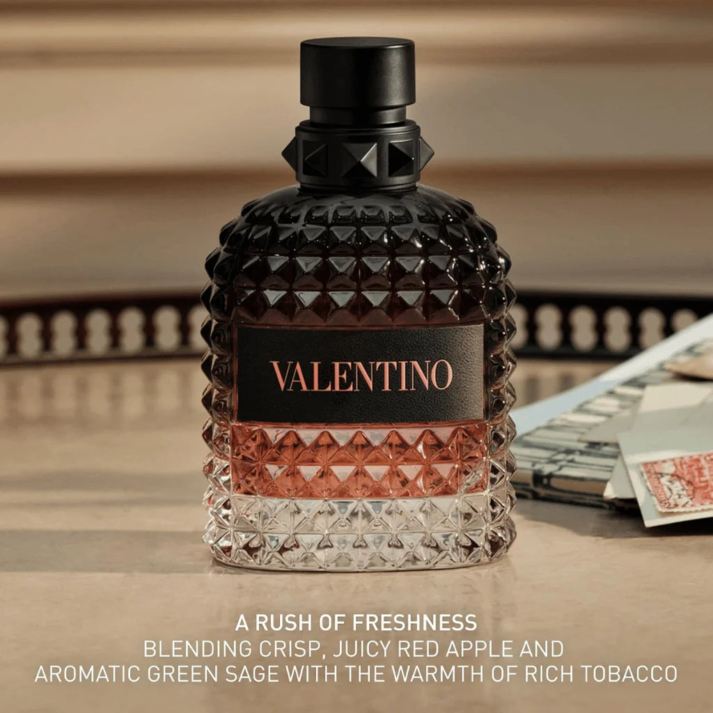 A bottle of Valentino fragrance with a faceted black and clear glass body, a black cap, and a black label with rose-gold lettering, set on a tabletop with blurred background elements and text overlay at the bottom.