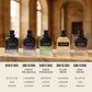 Five Valentino perfume bottles labeled Born in Roma are lined up on a wooden surface against a blurred warm interior background. The bottles have textured black, purple, green, yellow, and coral glass with black caps, and text below lists the scent notes for each fragrance.