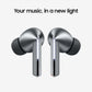 A pair of metallic silver wireless earbuds with black silicone tips, shown against a light gray background with the text 'Your music, in a new light' above them.